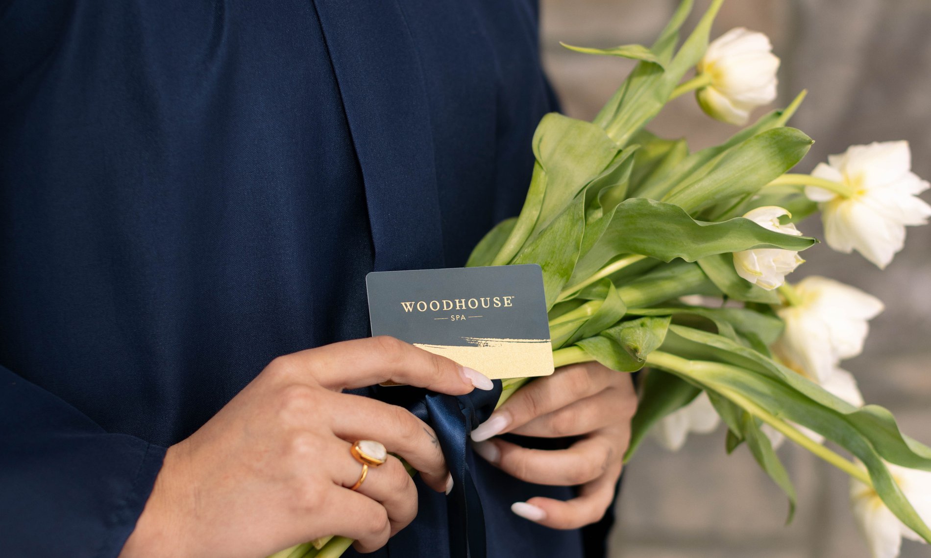 gradutate holding tulips and a woodhouse spa gift card