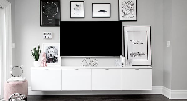 Modern floating media center with tv and pieces of wall art by California Closets Tampa Bay, Florida.