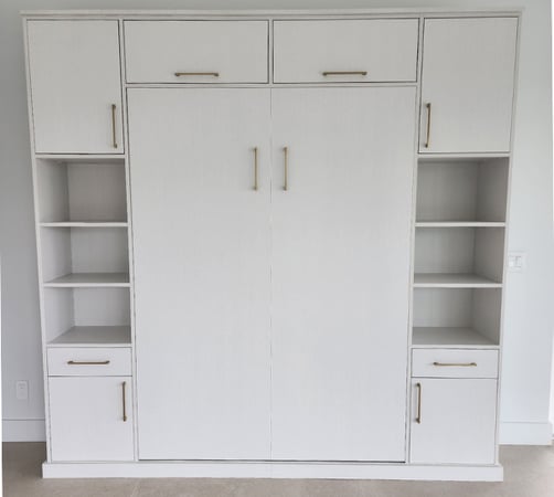 Custom white wall bed in Boca Raton, FL with elegant gold hardware and integrated storage by California Closets