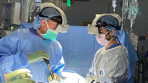 Photo of Richard (Todd) Allen, MD, PhD, using an augmented reality headset during a spine surgery at UC San Diego Health