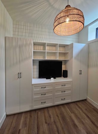 Custom media center with wood cabinets and wall-mounted TVs.