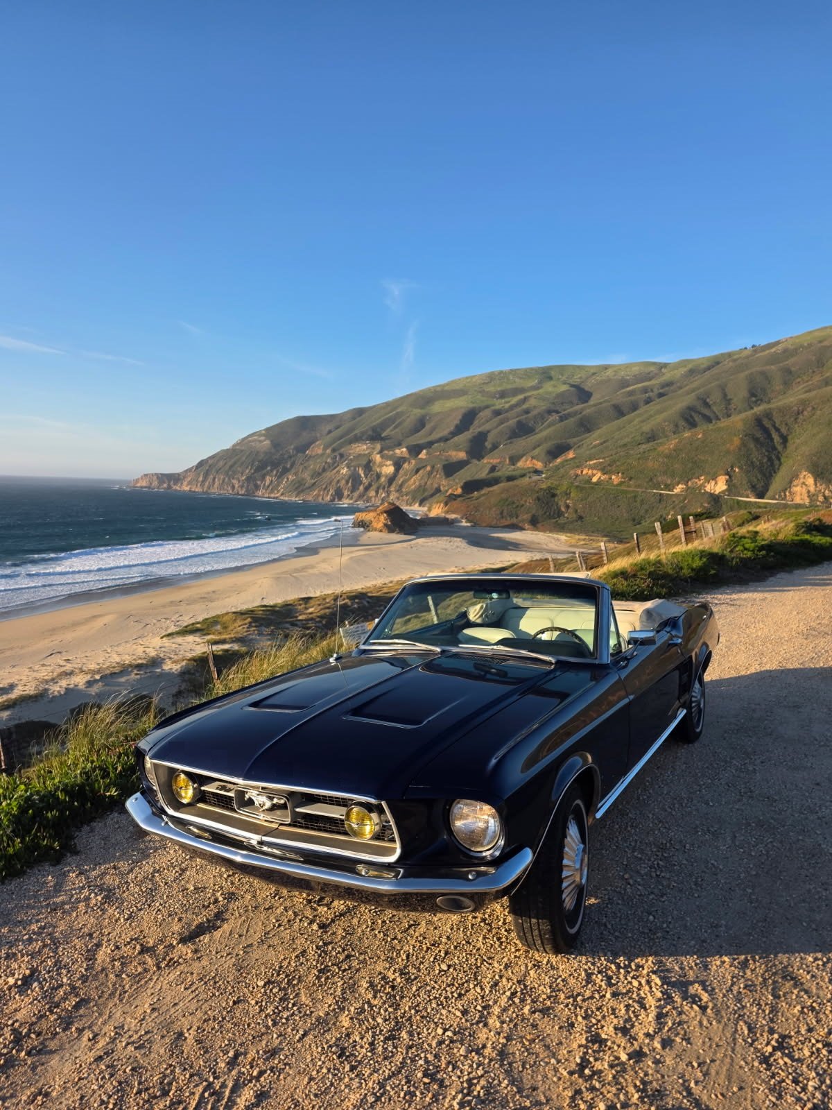 1967 Classic car, black, with California West Coast Highway and Pacific Ocean in the background, classic car.