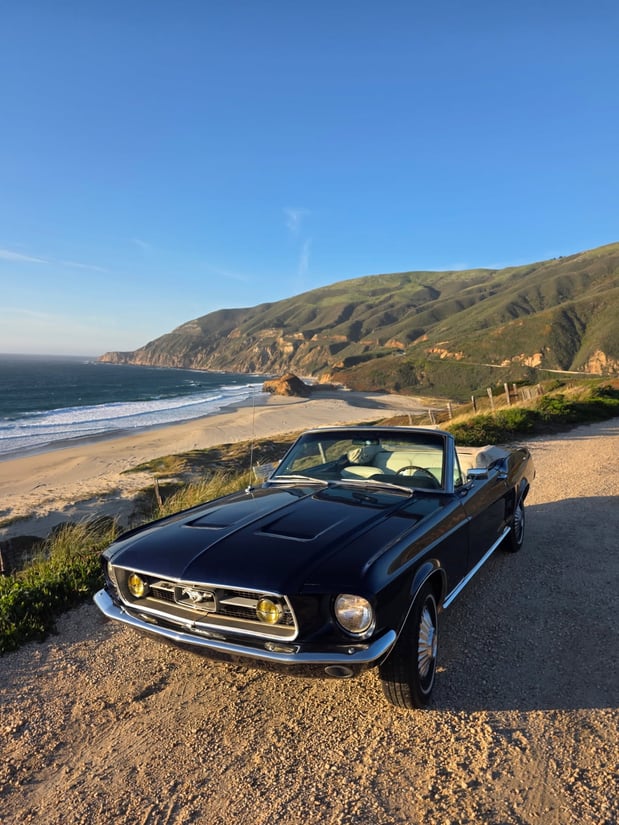 1967 Classic car, black, with California West Coast Highway and Pacific Ocean in the background, classic car.