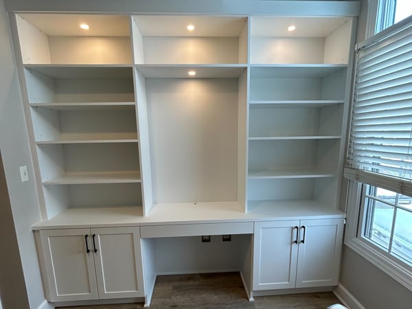 White desk with lighting, shelves and doors