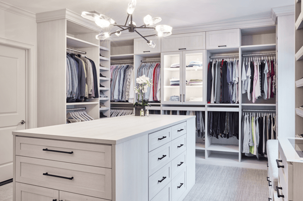Wardrobe dressing room with island, lit cabinets, shoe shelves by California Closets Norwalk, CT.