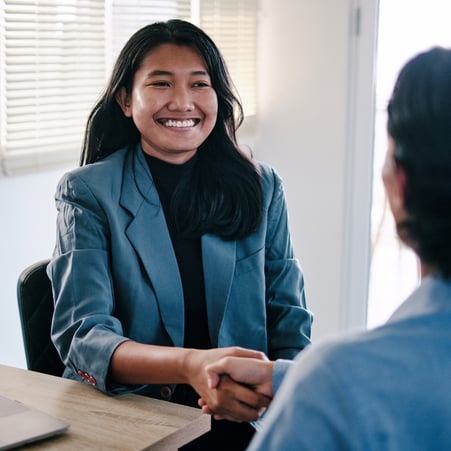 Young professional shaking hands with advisor.