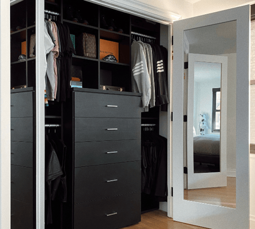 black reach-in closet with drawers, shelving and hanging space Manhattan New York