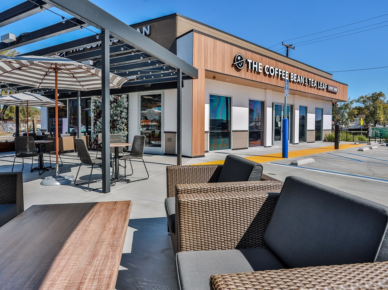 A store front of The Coffee Bean & Tea Leaf shows outdoor seating, surrounded by palm trees and nice CA weather