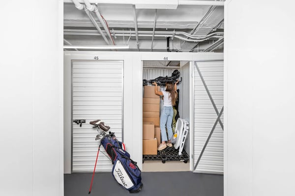 Woman packs her storage unit with baby stroller, golf clubs, boxes and more