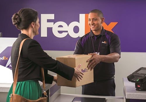 Woman picking up a hold for pickup package at a FedEx Express