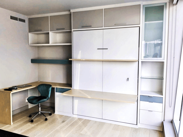 Office with wall bed featuring a desk and shelf that can be used when the bed is tucked away