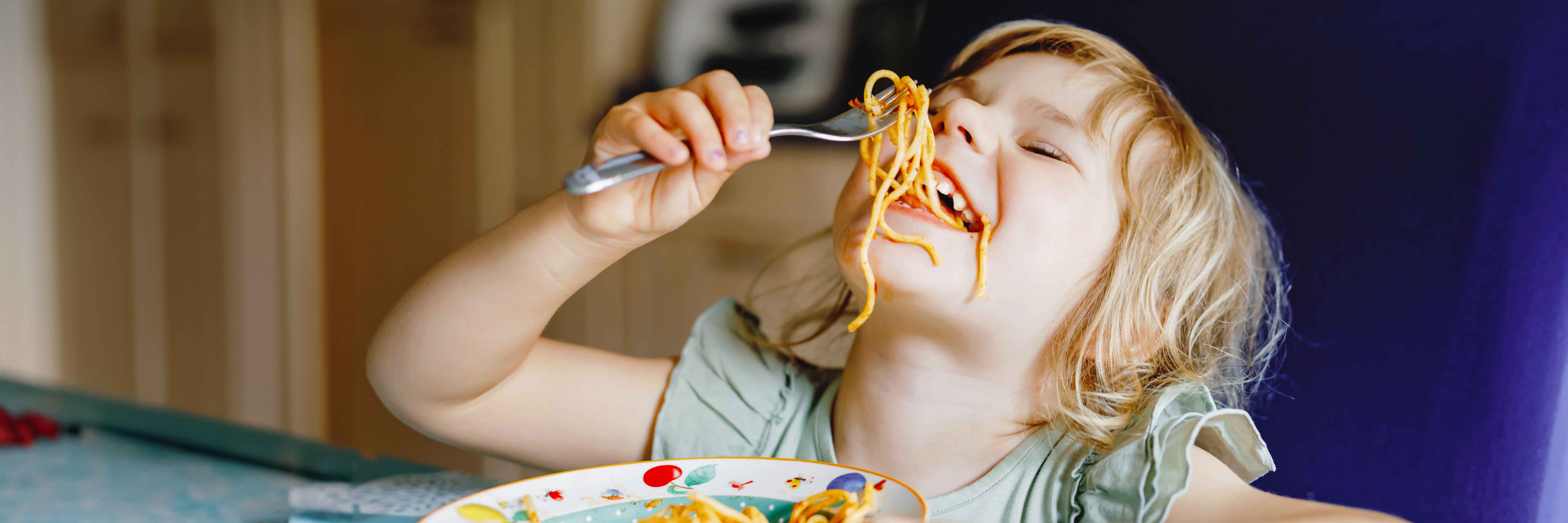 little girl eating spaghetti