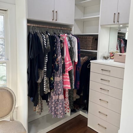 Built-in dresser drawers and cabinets inside a walk-in closet.