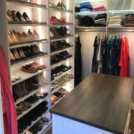 Greensboro - Custom closets - Beautiful walk-in closet with floor-to-ceiling shoe display racks, LED lights, organized clothing, and a center island