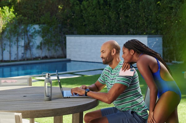 Family in backyard looking at laptop in Panama City Beach