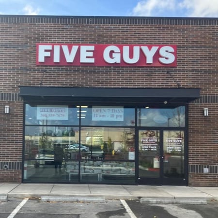 Exterior photograph of the entrance to the Five Guys restaurant at 4022 Pacific Avenue SE in Lacey, Washington.