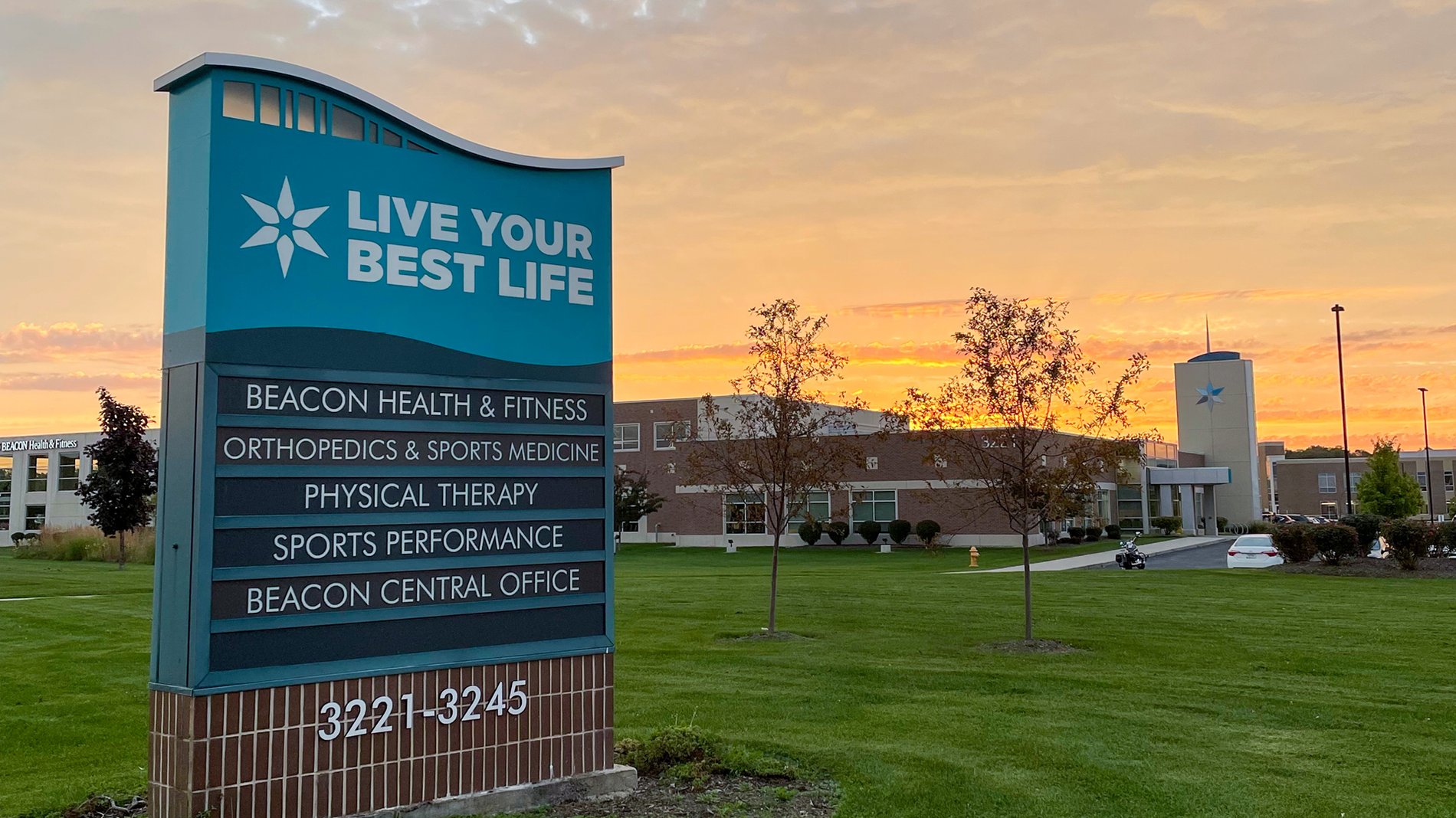 A teal sign in front of Beacon Health and Fitness in Granger says, "Live your best life." It lists orthopedics, sports medicine, physical therapy, sports performance and beacon central office.