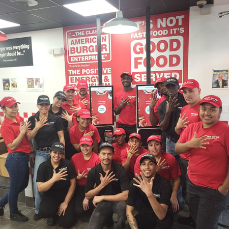 Employees pose for a photograph in the dining room of the Five Guys restaurant at 2847 Broadway in New York City.