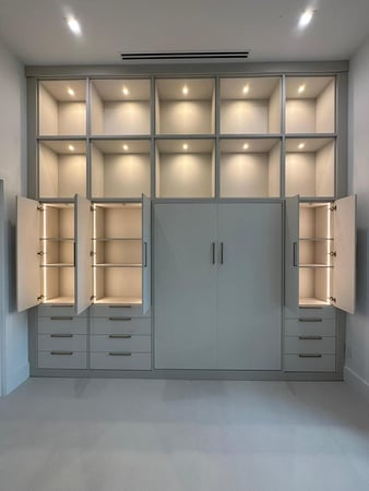 custom wall unit with ample shelving, cabinet & drawer space with a vertical full size wall bed