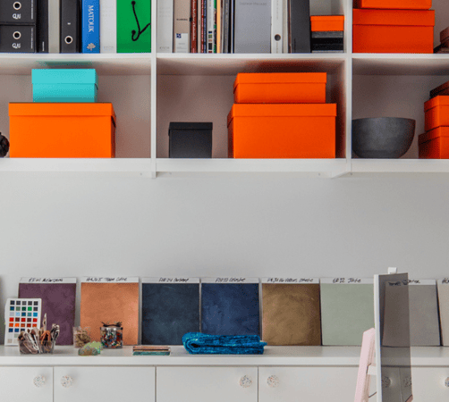 California Closets New York, NY Custom Commercial Space White Office Custom Bookshelves Storage Interior Design Studio with Closed Cabinets and two desk workspaces