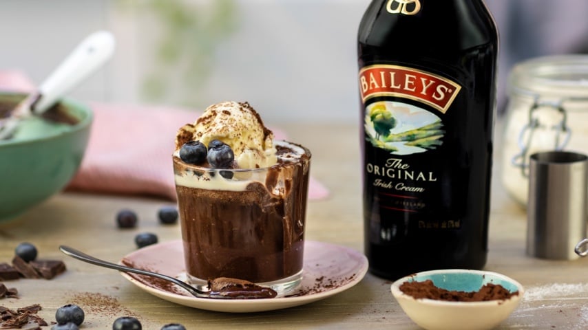 Cup of Baileys chocolate coffee cake with vanilla ice cream, cocoa powder and blueberries on top