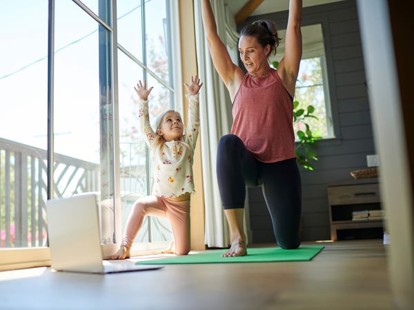 Madre e hija practicando yoga y disfrutando de los mejores planes de Internet de su área.