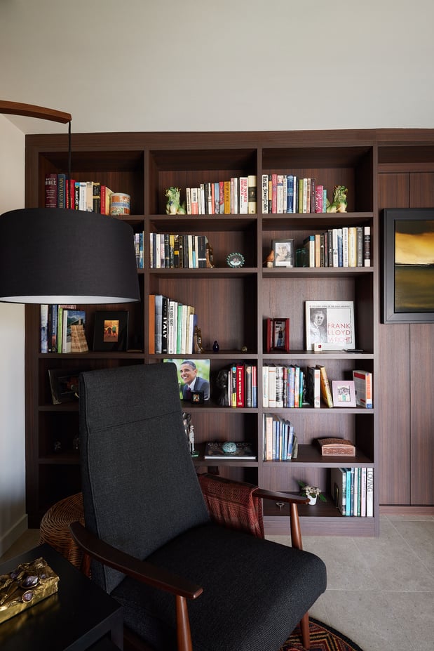 Dark home office shelving with books and chair
