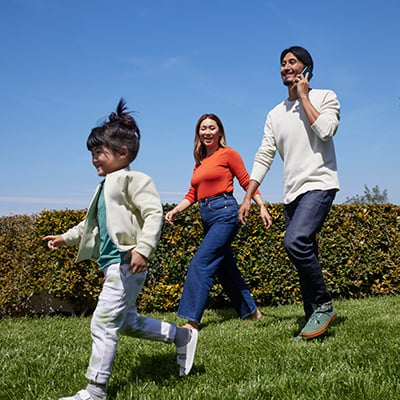 Familia caminando al aire libre usando el teléfono móvil con Xfinity Mobile