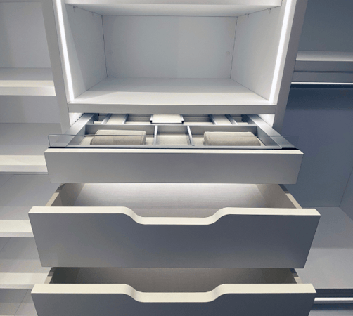 white luxury walk-in closet with drawers with modern scoop handles and luxury jewlery drawer organizer and LED lighting Chelsea New York