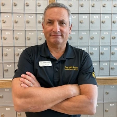 Male associate standing in front of mailbox bank at The UPS Store