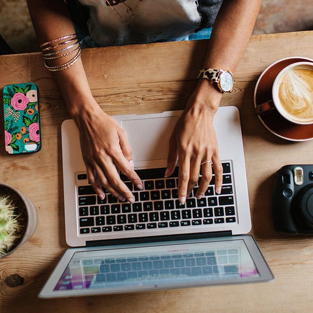 aerial view of woman typing on a laptop in a coffee shop