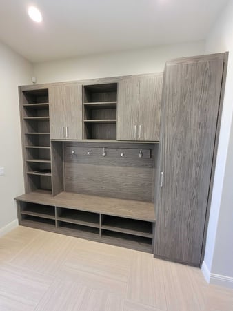 Grey garage mudroom storage with hooks and cabinets