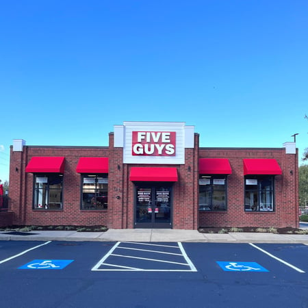 Exterior photograph of the entrance to the Five Guys restaurant at 2570 Lewisville-Clemmons Road in Clemmons, North Carolina.