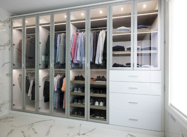 Custom Reach-In Closet with Glass Cabinet Doors White Built-In Cabinetry LED Shelf Lighting Double Hanging Sections Shoe Shelves and Drawer Storage by California Closets South Palm Beach Florida