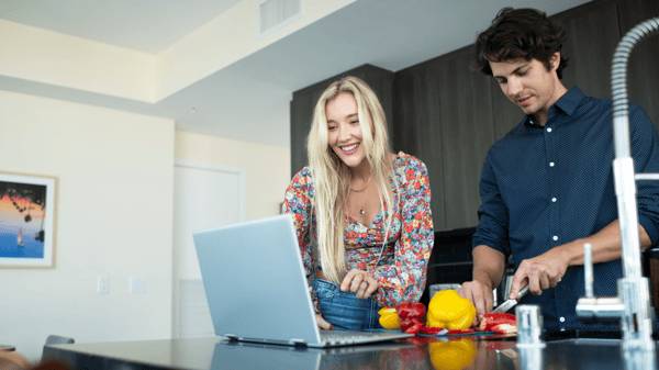 Pareja frente a una computadora portátil en la cocina en Henderson