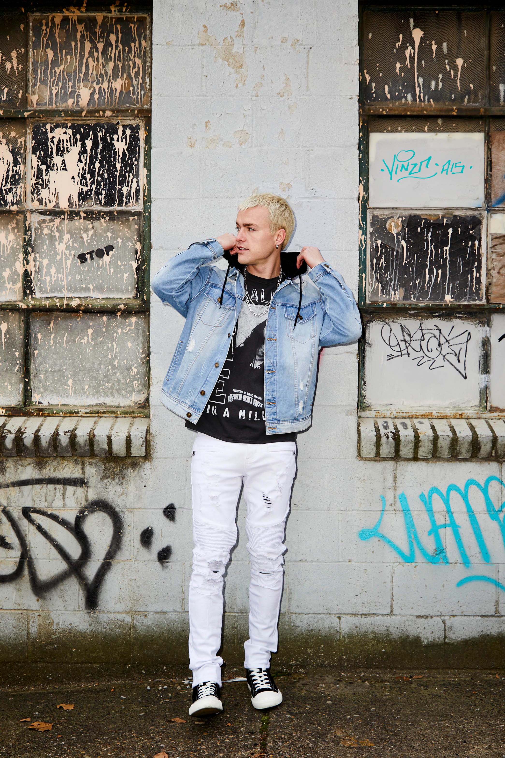 Male model wearing jeans, graphic tee, and jean jacket.
