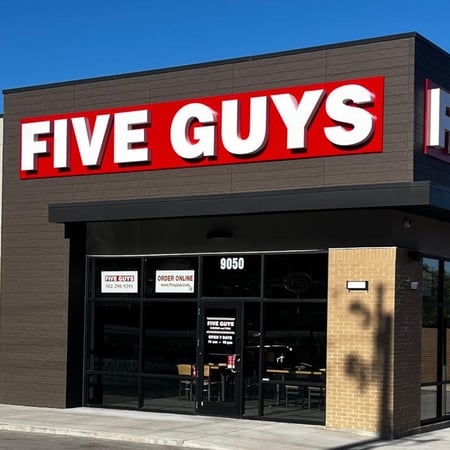 Exterior photograph of the entrance to the Five Guys restaurant at 9050 Dixie Highway 104 in Louisville, Kentucky.