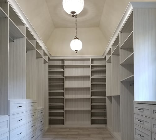 Walk-in closet with shoe storage, drawers, hanging space by California Closets Orange County.