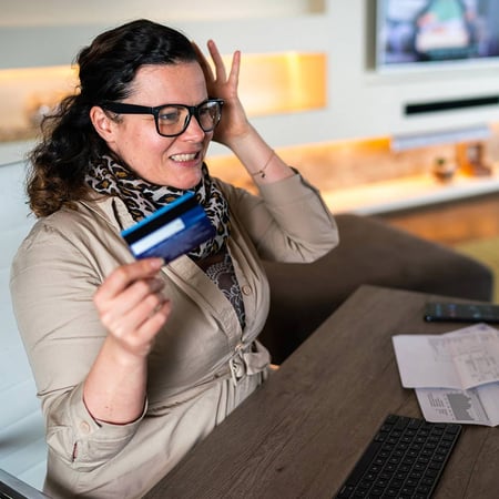 Woman looing frustrated holding a credit card
