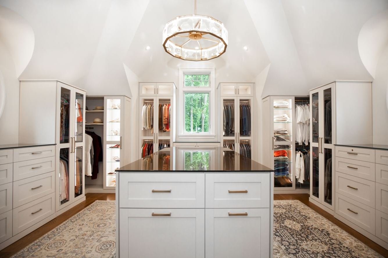 Attic Space Converted to Custom Dressing Room with Accent Lighting, Glass Doors and Shoe Shelves, Key-Lock Drawers, and Island with Tilt-Out Hampers for Laundry in Malvern, PA