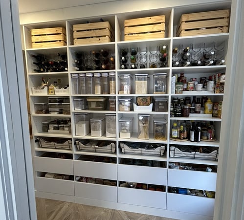 A pantry wall with shelves and drawers to organize dry goods