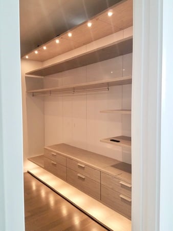 reach-in closet with led lighting california closets new york beige gray drawers hanging floating shelves