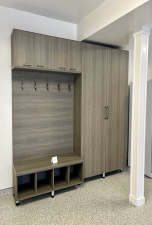 Garage storage system with custom storage, built-in cabinets, bench seating, and cubbies for home organization