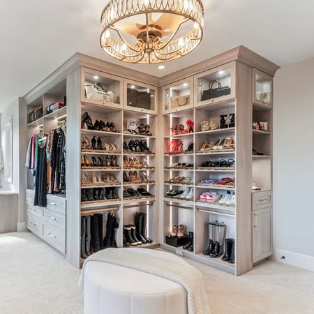 Custom neutral wardrobe with closet lighting and shoe storage by California Closets Greater Detroit, Michigan.
