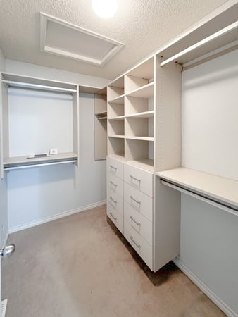 Simple walk in closed in a light finish with matte aluminum hardware.