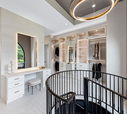 Custom walk-in closet with Glass doors, hanging space, and a vanity California Closets Greater Detroit