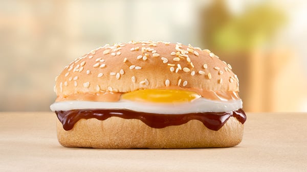 The Egg Bun on a brown surface with a blurred background.