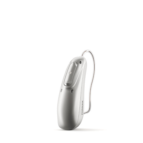 En modern hörapparat från Phonak i silvergrå finish med synlig knapp och mikrofonöppningar, sedd från sidan.