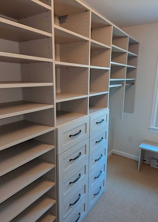 A walk-in closet with drawers, cubbies, and shelves.