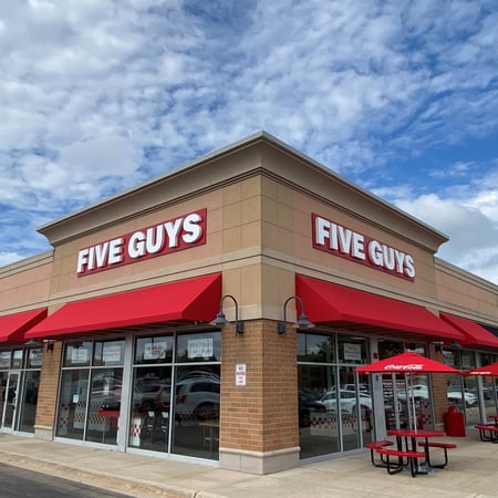 Exterior photograph of the entrance to the Five Guys restaurant at 2446 Sycamore Road in Dekalb, Illinois.